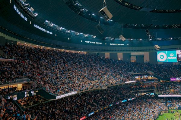 A packed stadium with a large crowd, displaying player names and years on the interior.