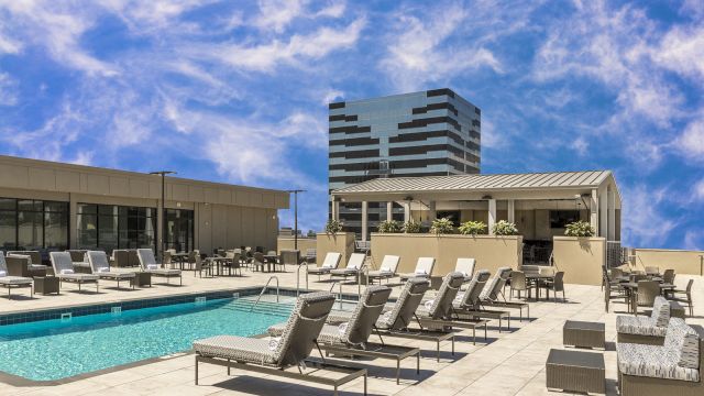 A rooftop pool area with lounge chairs and a swimming pool