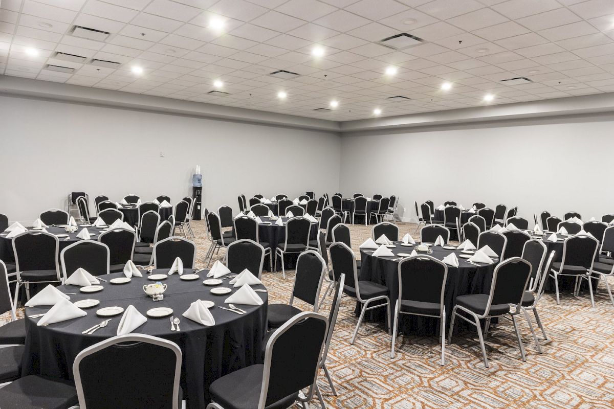 A large meeting room with round tables set for a formal event.